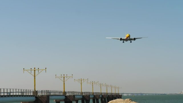 Widebody airplane approaching at Hong Kong airport. Approach lighting system of airport. Guiding lights on runway for landing commercial air plane, ILS.