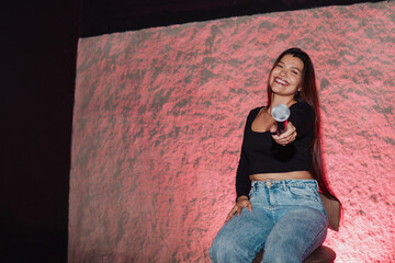 beautiful young Latina woman with a microphone in karaoke or singing