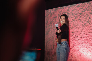 beautiful young Latina woman with a microphone in karaoke or singing