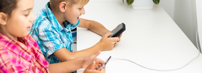 Education, friendship, technology and people concept. children using mobile phone, pointing...