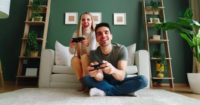Couple playing video games at home on weekend morning