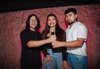 LGBT friends holding a microphone singing in a bar or karaoke