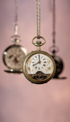 Pocket watch, beautiful and antique pocket watches hanging in front of an abstract background, selective focus.