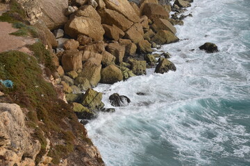 Waves crash against the rocky shoreline of Sagres, Algarve, Portugal. The steep cliffs and rugged coast highlight the region’s wild Atlantic beauty.