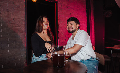 LGBT couple friends sitting drinking beer in a bar