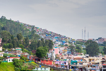 Fototapeta premium Colorful Hillside Residences Overlooking the Green Valleys of Ooty, Western Ghats