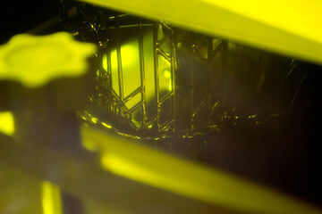 Working of photopolymer sla 3D printer. Platform with building object lowered into liquid...