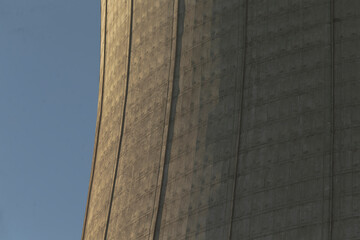 This is a detailed closeup view of a distinctive cooling tower set against a beautiful blue sky,...