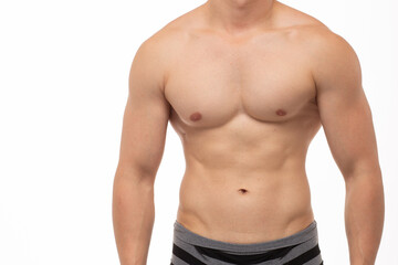 A young athletic guy with an athletic build and a smooth body poses against a white isolated...
