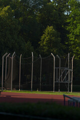 There is a fence that surrounds a track while trees can be seen in the background providing a...