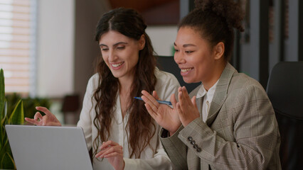 African American Caucasian female office coworkers happy cheerful girls ladies business partners businesswomen rejoice win online computer betting laptop screen multiracial women celebrate high five