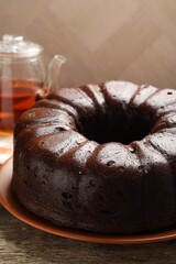 Tasty chocolate bundt cake on wooden table, closeup
