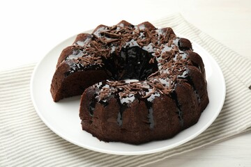 Delicious chocolate bundt cake on light wooden table, closeup