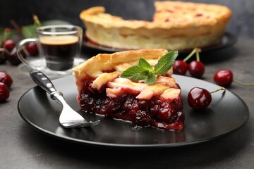 Piece of tasty cherry pie and berries on grey table, closeup