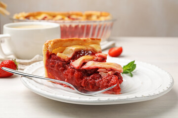 Piece of tasty strawberry pie and berries on white wooden table, closeup
