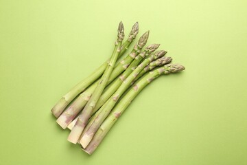 Fresh ripe raw asparagus on green background, top view