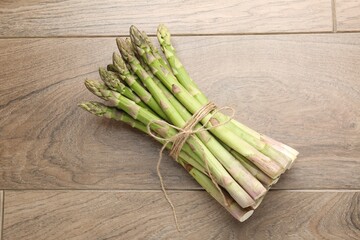 Fresh raw asparagus spears on wooden table, top view