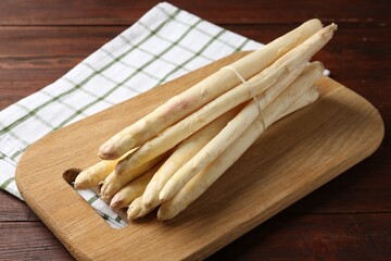 Raw asparagus spears on wooden table, closeup
