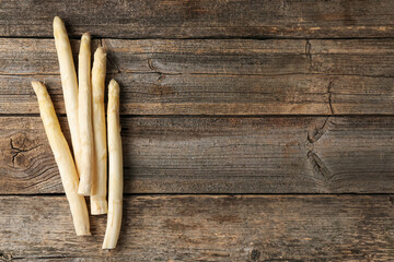Raw white asparagus spears on wooden table, flat lay. Space for text