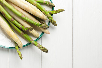 Different raw asparagus spears on white wooden table, top view. Space for text