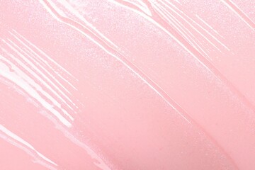 Sample of clear lip gloss on pink background, top view