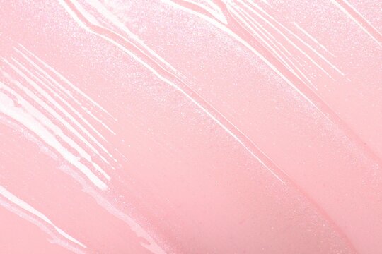 Sample of clear lip gloss on pink background, top view
