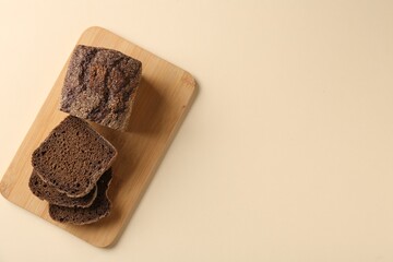 Pieces of fresh rye bread on beige background, top view. Space for text
