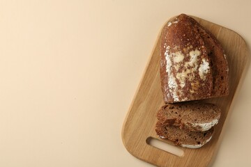 Pieces of fresh rye bread on beige background, top view. Space for text