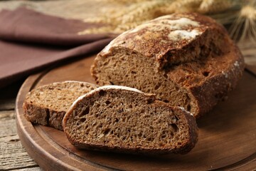 Pieces of fresh rye bread on wooden table, closeup