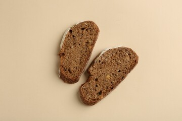 Pieces of fresh rye bread on beige background, top view