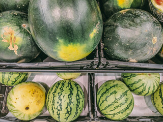 A bunch of watermelons are displayed in a crate