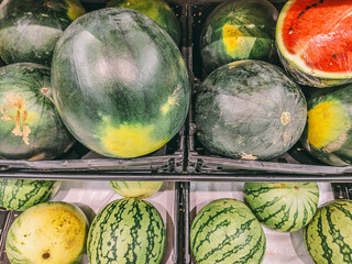 A bunch of watermelons are displayed in a store