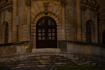 Beautiful entrance door to baroque medieval style old church building on nature bright evening light and sky background. Europe religion architecture building