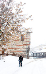 Heavy snowfall in Erzurum with a lone walker in winter street scene.