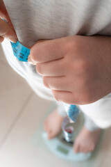 High angle view of a person checking their body measurements and weight for health indicators