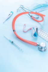 Medical tools and accessories, including a stethoscope, pills, medical mask and electronic thermometer, arranged on a light background, symbolizing healthcare, diagnosis, and medical practice