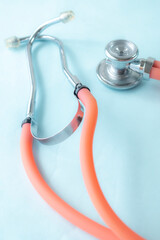 Close up of medical-themed composition featuring stethoscope on blue background. Perfect for illustrating healthcare, diagnostics, or cardiology-related concepts.