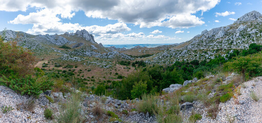 breathtaking view from Mali Alan across Tulove Grede, where rugged limestone peaks and rocky terrain stretch under a dramatic sky of scattered clouds, blending wild beauty with a vast, untouched