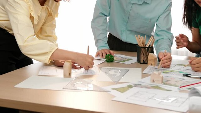 A video of architect use measurement tools and pencil to measure blueprint. Architect design house construction on a table at studio, with architectural plan scattered around. Focus hand. Delineation.