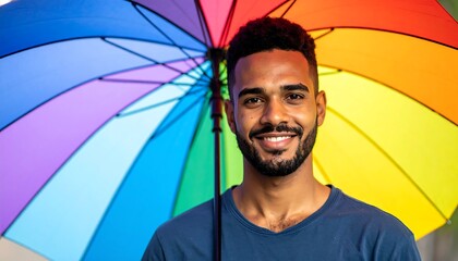 Man smiles under rainbow umbrella