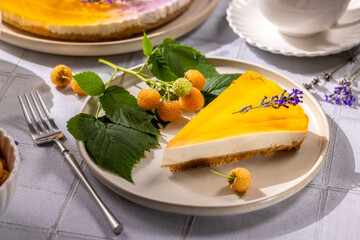 Delicious orange cheesecake slice with lavender and yellow raspberries on elegant plate