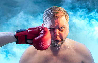 Shocked man getting punched by red boxing glove getting hit in face  with dramatic impact