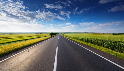 open highway stretching through rural fields under blue sky