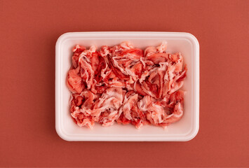 pork scraps in a food tray of polystyrene foam.  発泡スチロールの食品トレーに入った豚のこま切れ