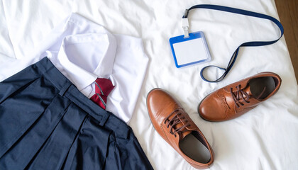 Flat Lay of School Uniform, Shoes, and ID Card on Bed, Morning Preparation Setup