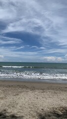 A serene beach scene with gentle waves rolling onto the sandy shore, under a beautiful blue sky...