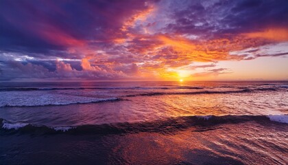 Obraz premium vibrant sunset over ocean waves on a sandy beach
