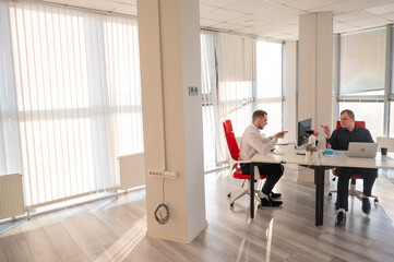 Two Caucasian men working in an office. 