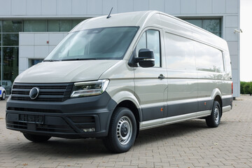 One white minibus parked on paved road outdoors