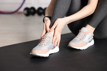 Sports injury. Young woman suffering from leg pain in fitness studio, closeup
